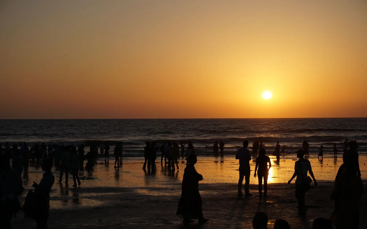 Silhouettes of people on a Bali beach at sunset
